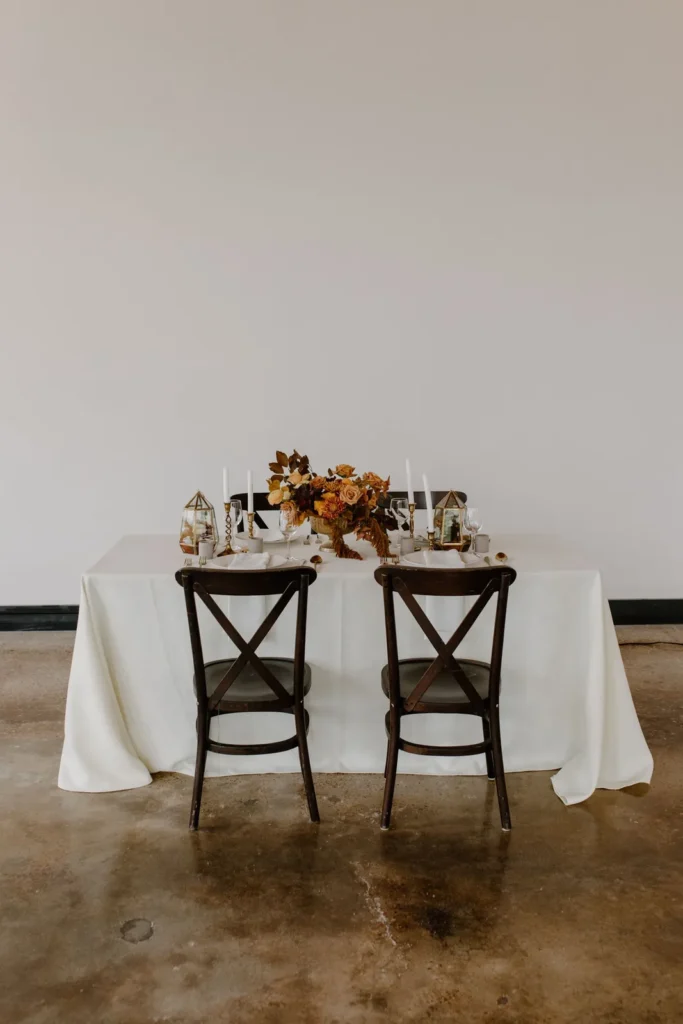 A simple wedding table setting with candles and pale flowers
