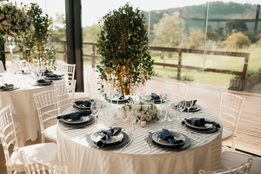 A wedding table beside a large window overlooking green countryside